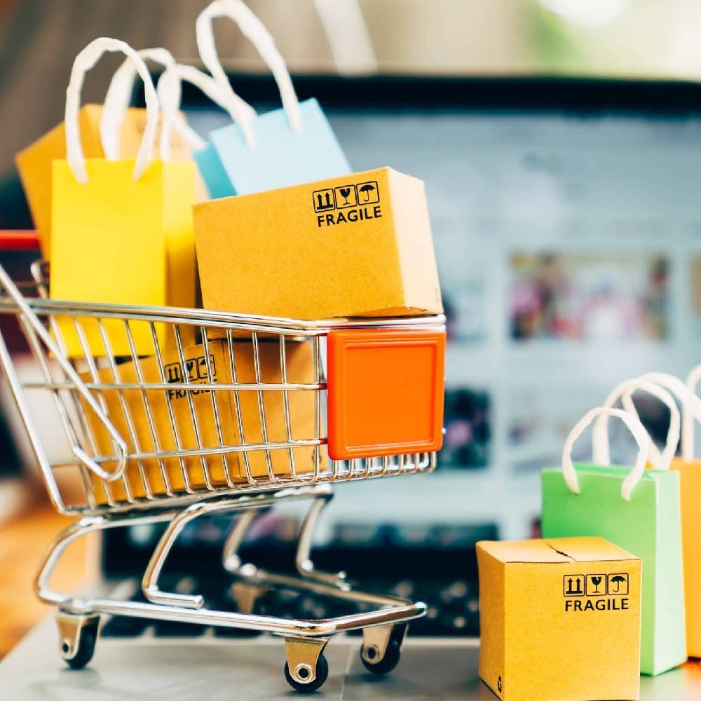 A small shopping cart filled with colorful parcels and gift bags